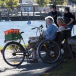 Immagine di un anziano alla guida con un documento di patente in mano, simbolo del nuovo limite di età europeo.