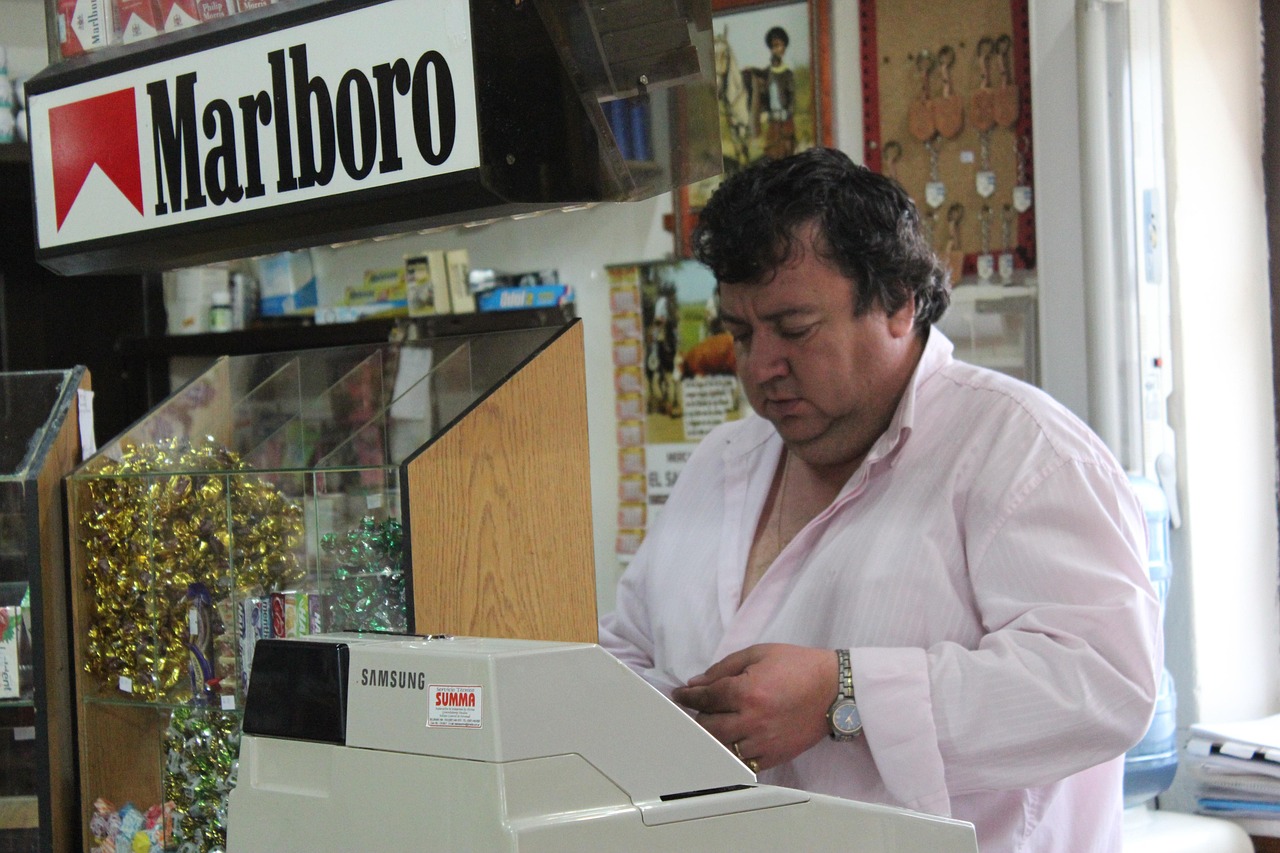 Un tabaccaio mostra un Gratta e Vinci vincente con un sorriso soddisfatto.