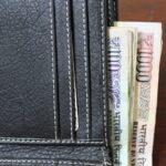 Immagine di un uomo che controlla il saldo del conto su uno smartphone, evidenziando il tema dei prelievi in contanti.