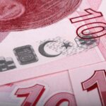 Banconota in primo piano con testo "Dismessa il 27 gennaio", simboli monetari e sfondo neutro.